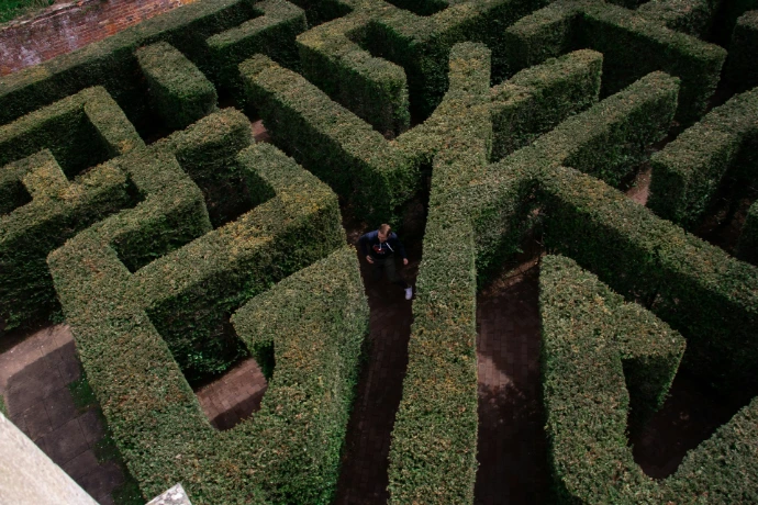 person in black jacket walking on green grass field